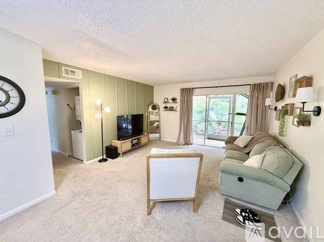 A living room with a flat screen TV and a green couch.