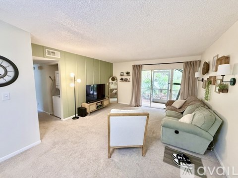 A living room with a flat screen TV and a green couch.