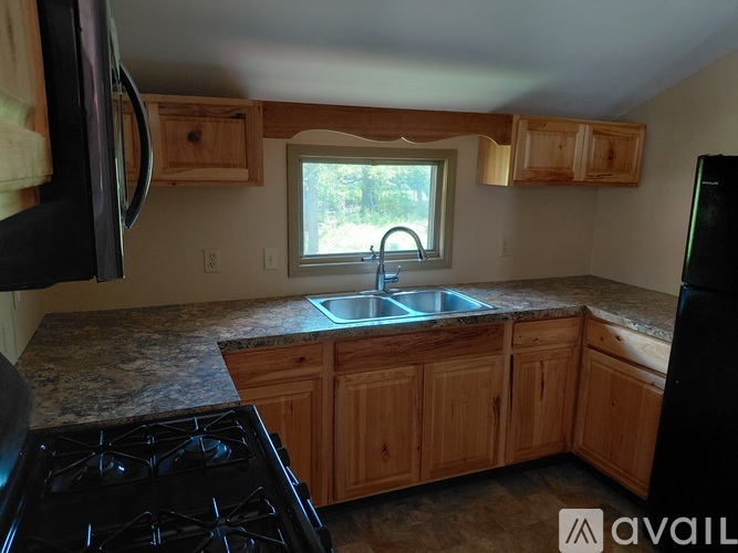 A kitchen with wooden cabinets and a granite countertop.