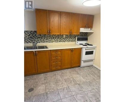 A kitchen with wooden cabinets and a white stove top oven.