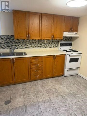 A kitchen with wooden cabinets and a white stove top oven.