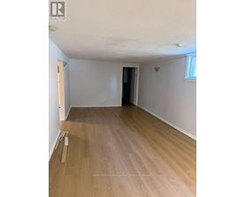 A room with wooden flooring and white walls.