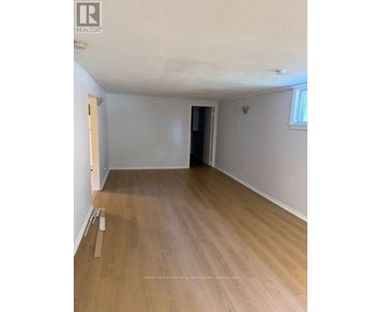 A room with wooden flooring and white walls.