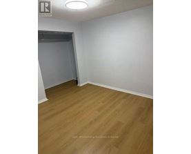 A room with wooden flooring and white walls.