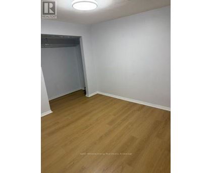 A room with wooden flooring and white walls.