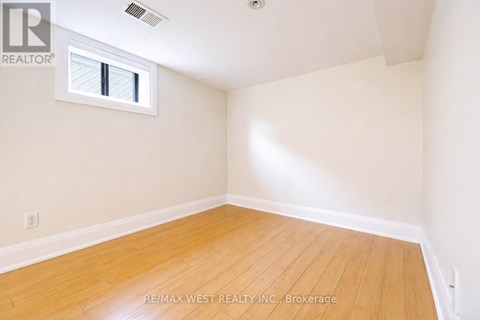 A room with a window and wooden flooring.