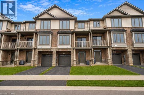 A row of townhouses with a realtor logo in the corner.