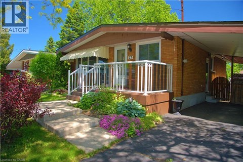 A house with a red brick exterior and a white porch.