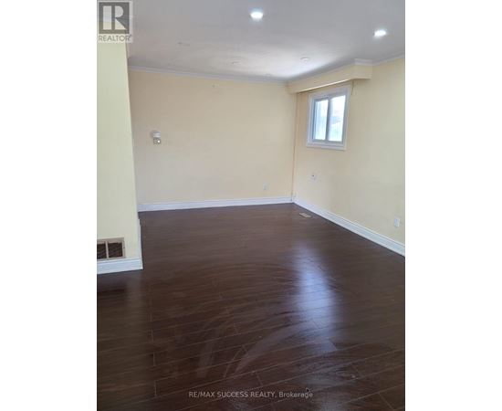 A room with a window and a wooden floor.