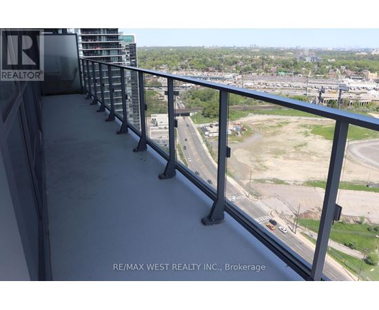 A balcony with a view of a highway and buildings.