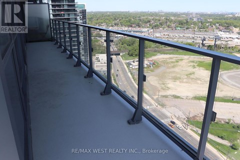 A balcony with a view of a highway and buildings.