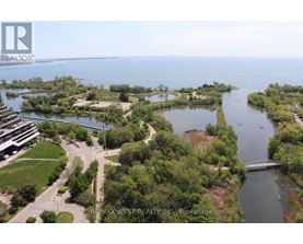 A bird's eye view of a waterfront property with a bridge and a building in the distance.