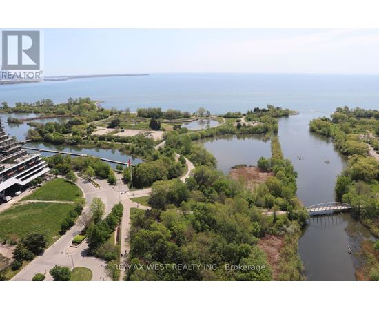 A bird's eye view of a waterfront property with a bridge and a building in the distance.