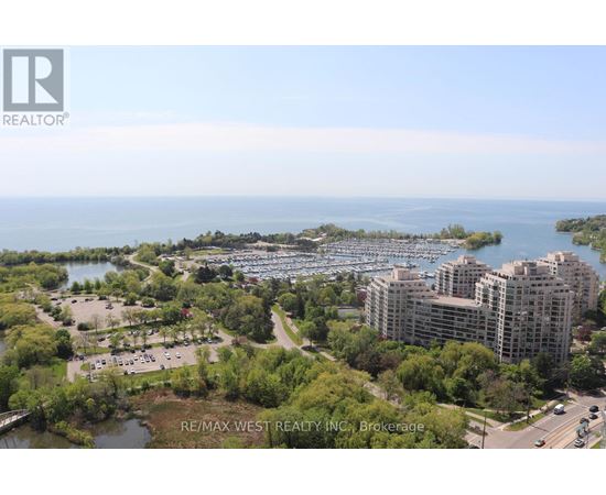 A bird's eye view of a city with a body of water and apartment buildings.