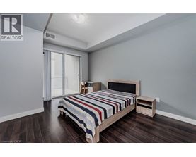 A bedroom with a bed, nightstand, and sliding glass doors.