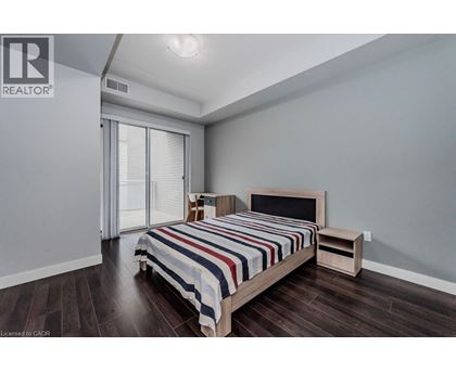 A bedroom with a bed, nightstand, and sliding glass doors.