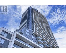 A tall building with a blue sky and clouds in the background.