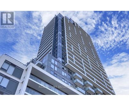 A tall building with a blue sky and clouds in the background.