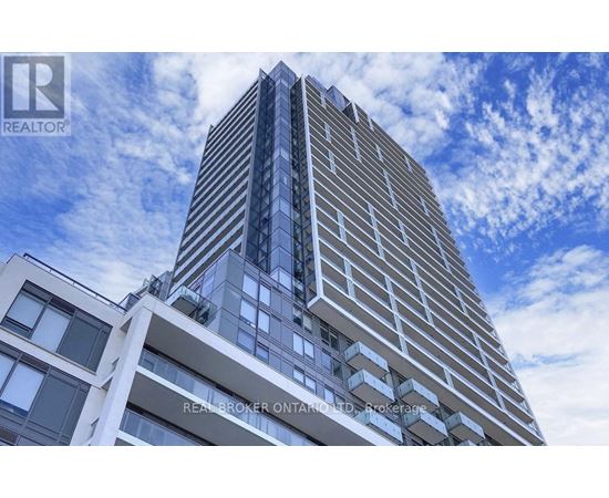 A tall building with a blue sky and clouds in the background.