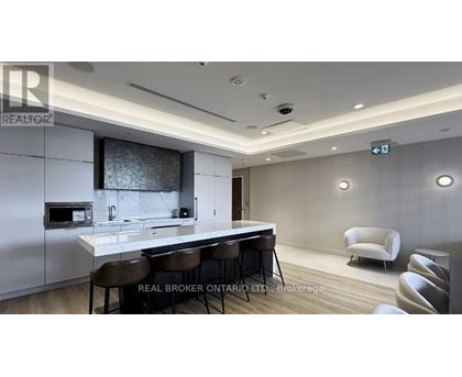 A modern kitchen with a bar area and chairs.
