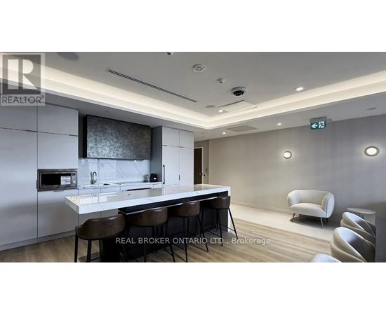 A modern kitchen with a bar area and chairs.
