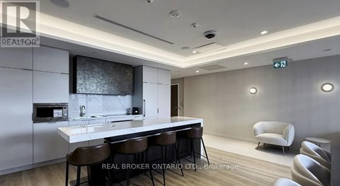 A modern kitchen with a bar area and chairs.