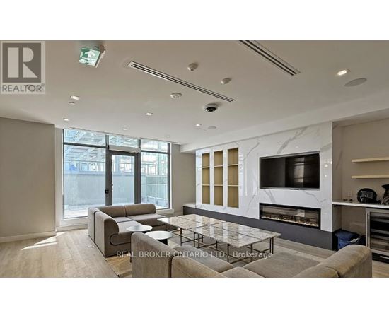 A modern living room with a grey sofa and a glass coffee table.