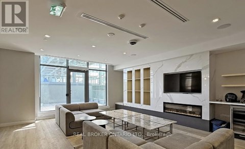 A modern living room with a grey sofa and a glass coffee table.
