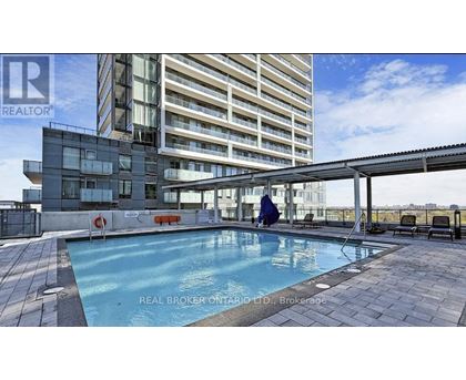 A swimming pool area in front of a multi-story residential building.