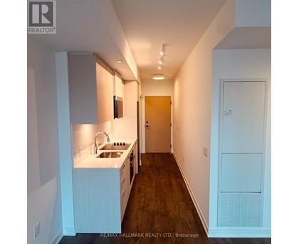 A kitchen with white cabinets and a sink.