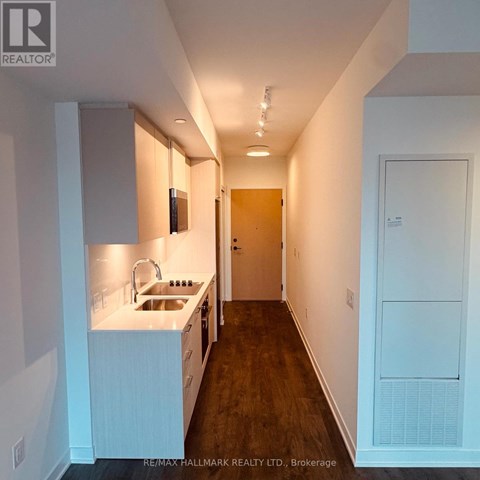 A kitchen with white cabinets and a sink.