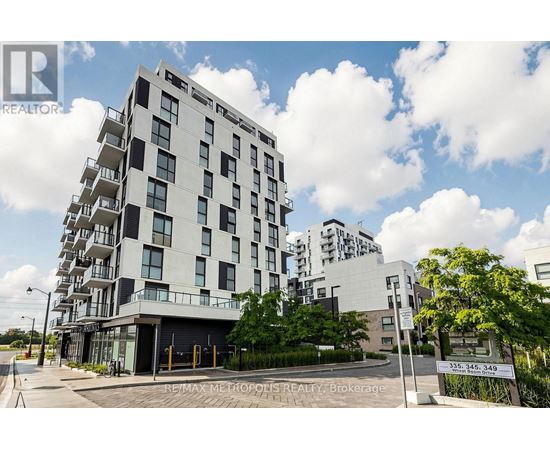 A modern apartment building with a sign in front that reads "RE/MAX METROPOLITES REALTY Brokerage".