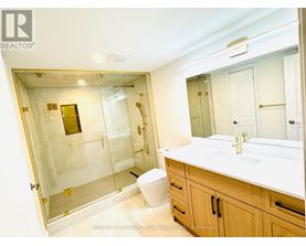 A bathroom with a walk-in shower, toilet, and sink.