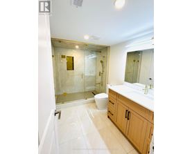 A bathroom with a toilet, sink, and shower.