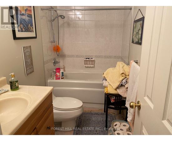 A bathroom with a toilet, sink, and bathtub.