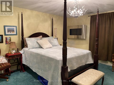 A bedroom with a four poster bed and a chandelier.