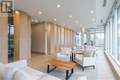 A spacious living room with a long wooden table and white chairs.