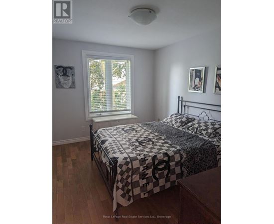 A bedroom with a bed and a window.