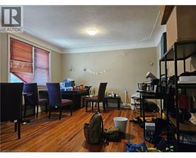 A room with a table, chairs, and a backpack on the floor.