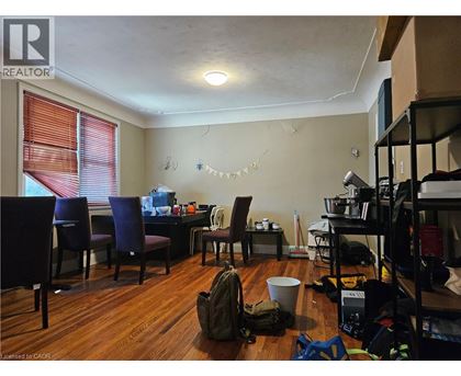 A room with a table, chairs, and a backpack on the floor.