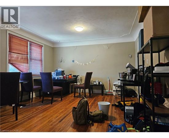 A room with a table, chairs, and a backpack on the floor.