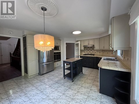 A modern kitchen with a large island and stainless steel appliances.