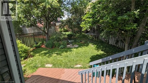 A backyard with a deck and a green lawn.