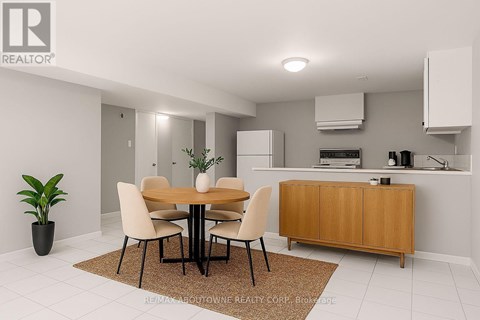 A dining room with a table and chairs and a plant in a pot.
