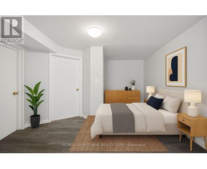 A bedroom with a bed, nightstand, and lamp.