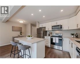 A modern kitchen with a white island and stainless steel appliances.
