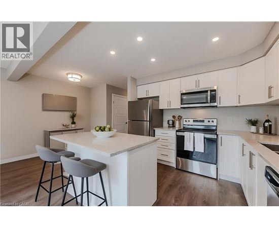 A modern kitchen with a white island and stainless steel appliances.