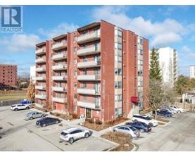 A red brick apartment building with cars parked in front.