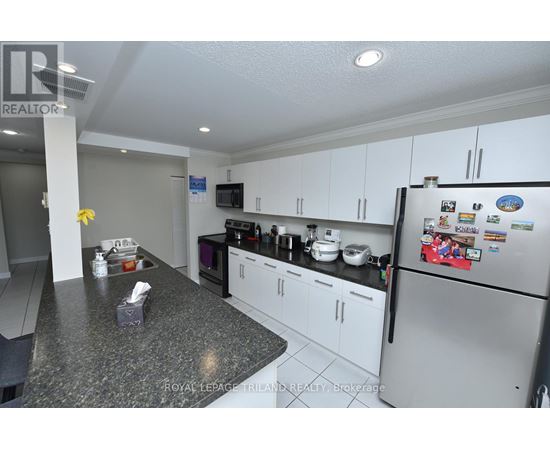 A kitchen with a refrigerator covered in magnets and a counter with a tissue box and napkins.