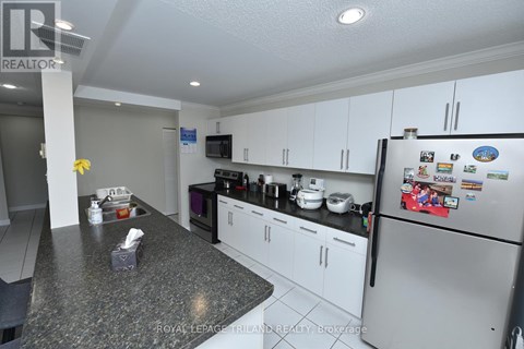 A kitchen with a refrigerator covered in magnets and a counter with a tissue box and napkins.
